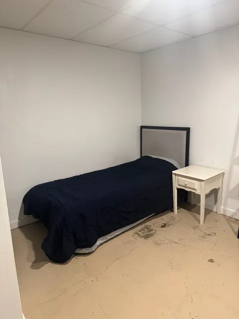 Bedroom at the 2091 4th Ave E house with a twin bed, gray upholstered headboard and white nightstand