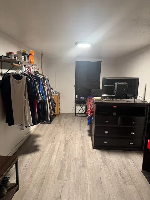 Long bedroom at the 2091 4th Ave E house with a clothes rail, dresser and wood-look floor