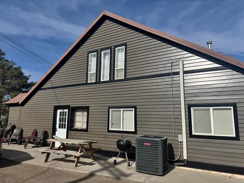 Exterior of the 2091 4th Ave E house with patio chairs, picnic table, grill and AC unit