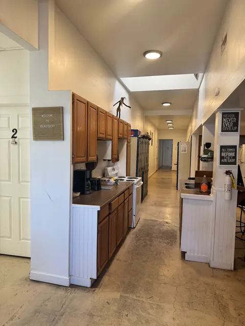 Galley kitchen at the 2091 4th Ave E house with oak cabinets, an electric range and a sink counter along the hallway