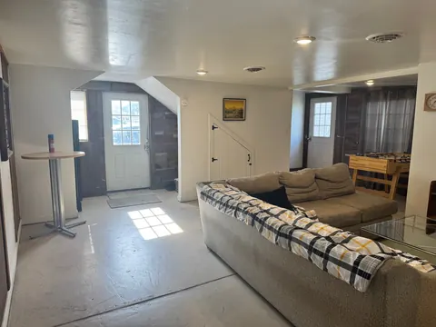 Common room with a sectional sofa, foosball table and two entry doors at the 2091 4th Ave E house