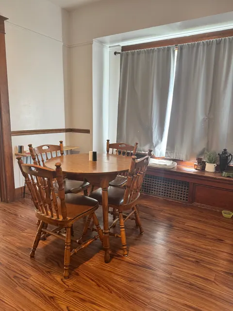 Dining area at the 212 4th Ave E house with a round wooden table, four chairs and a window seat