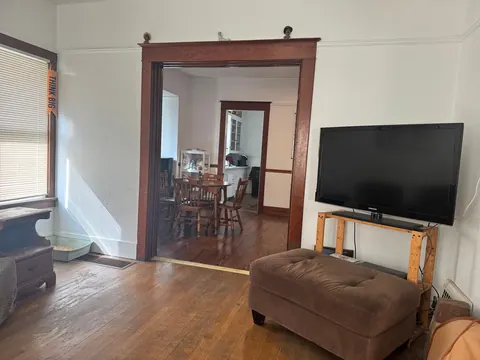 Living room at the 212 4th Ave E house looking through a wide wood-trimmed doorway into the dining area