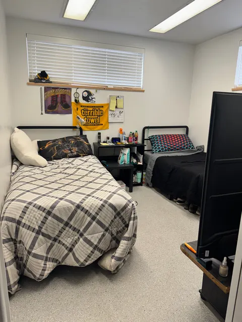 Shared bedroom at the 676 Shoup Ave W house with two twin beds, a nightstand and a high window