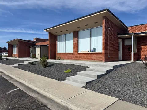 Brick front and landscaped entry walk of the 676 Shoup Ave W house on a sunny day