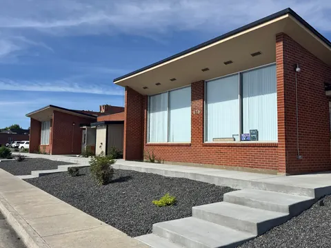 Angled view of the brick 676 Shoup Ave W house with new steps and gravel landscaping