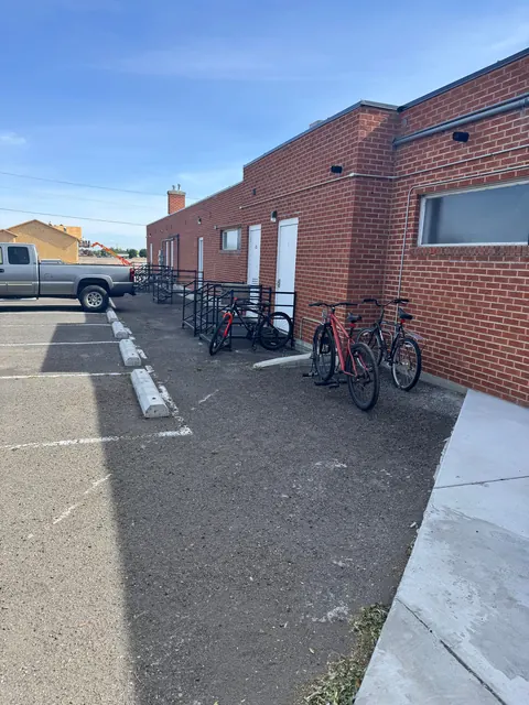 Rear of the 676 Shoup Ave W house with metal entry stairs, bike racks and a parking lot