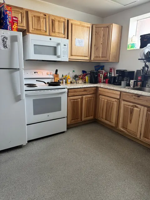 Kitchen at the 676 Shoup Ave W house with a white range, microwave, refrigerator and wood cabinets