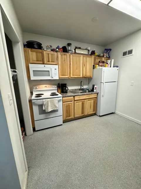 Kitchen at the 676 Shoup Ave W house with hickory cabinets, white range, microwave and top-freezer refrigerator