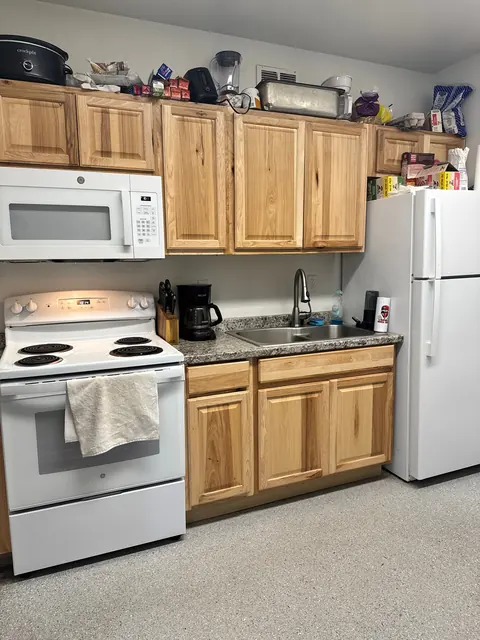 Closer view of the 676 Shoup Ave W kitchen with a white range, double sink, hickory cabinets and refrigerator